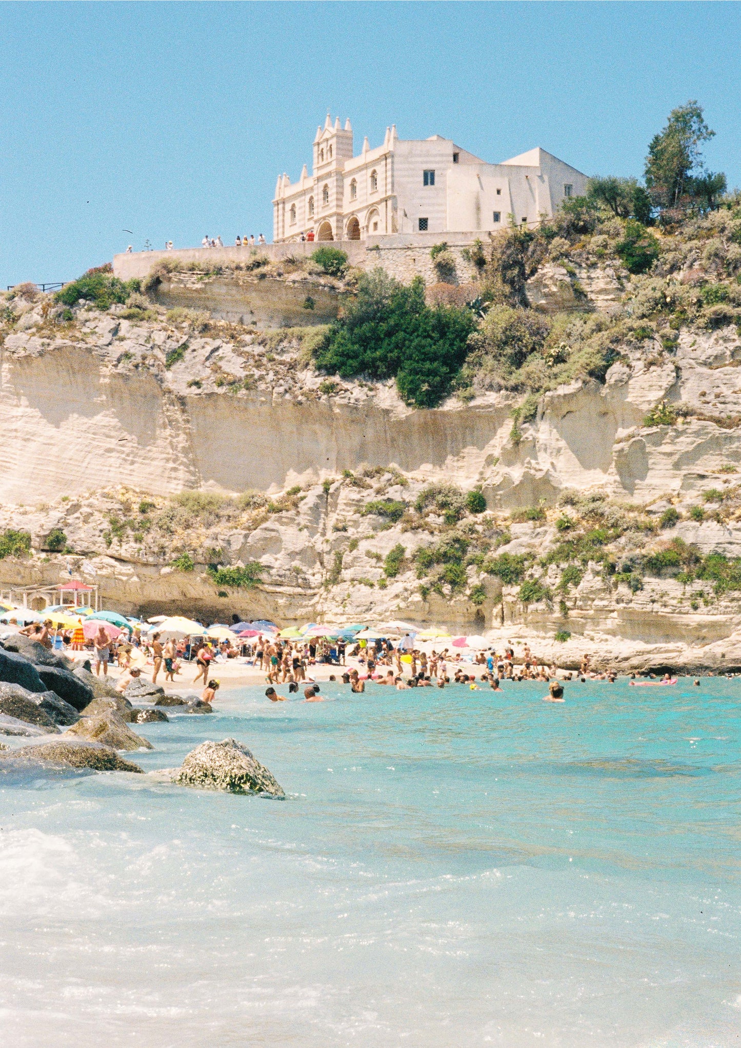 Fine art photograph titled “Spiaggia di Tropea,” capturing the turquoise waters and golden cliffs of Calabria’s most iconic beach. With sunbathers, umbrellas, and dramatic coastal scenery, this image brings southern Italy’s warmth and vibrancy into any coastal or travel-inspired space.