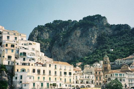 Fine art landscape print titled “Tra Mare e Monti,” depicting the dramatic meeting point of rugged mountains and the shimmering Mediterranean Sea along the Italian coast. This evocative photograph blends natural contrast and timeless beauty—ideal for nature-inspired or Mediterranean-styled interiors.